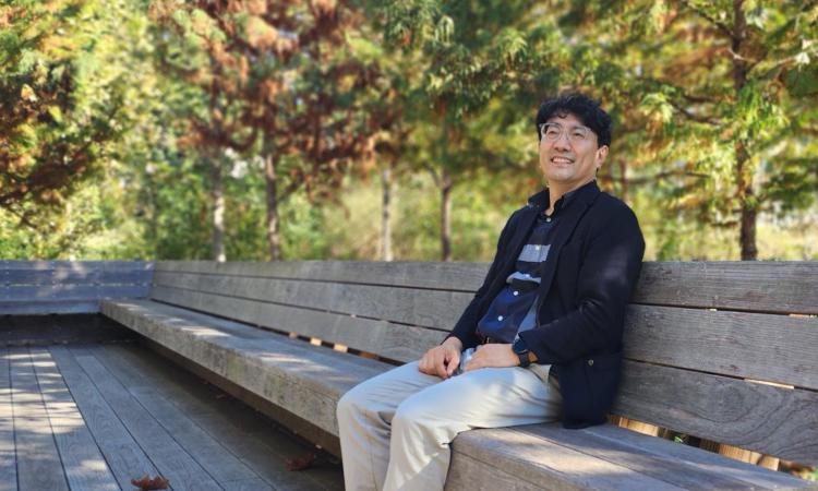Sanghyun Jang sitting at a bench at Georgia Tech EccoCommons