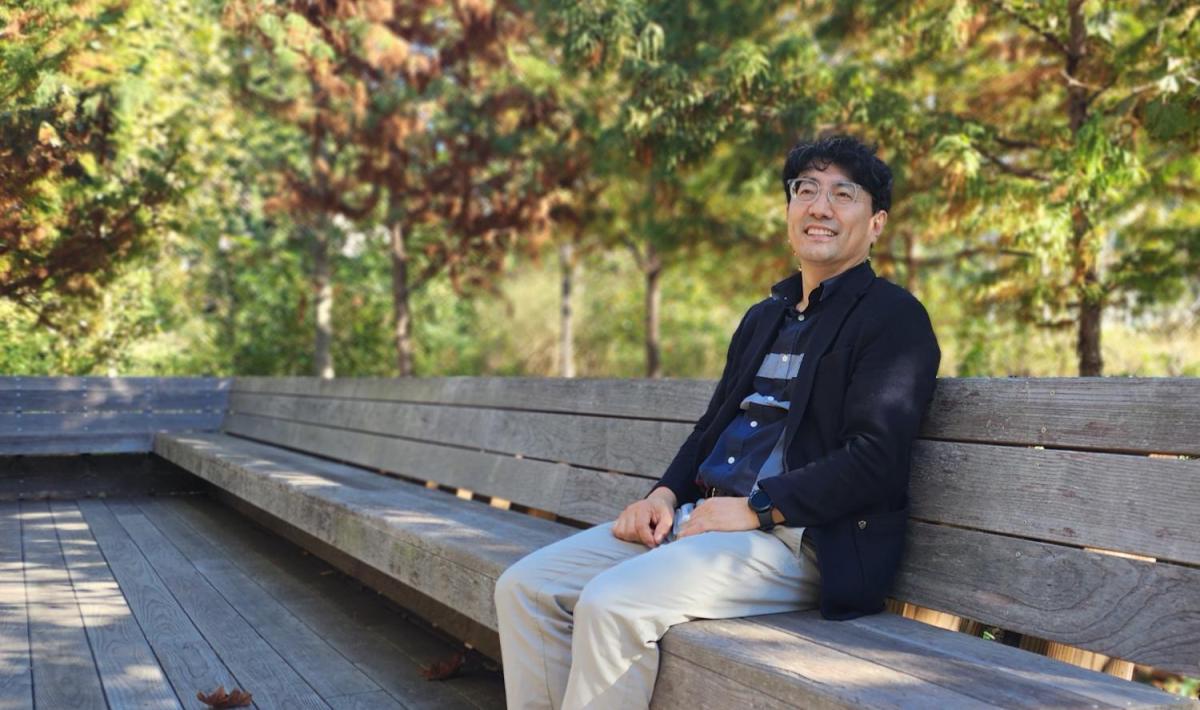Sanghyun Jang sitting at a bench at Georgia Tech EccoCommons